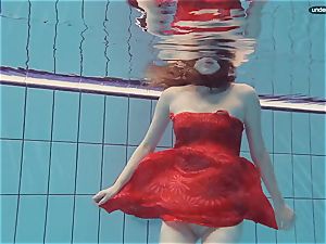 crimson clad teenager swimming with her eyes opened